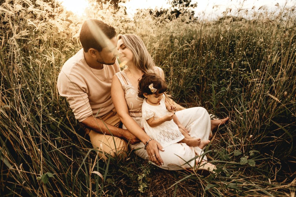 Twelve Months of Sunshine Young Family Sitting in Field photo